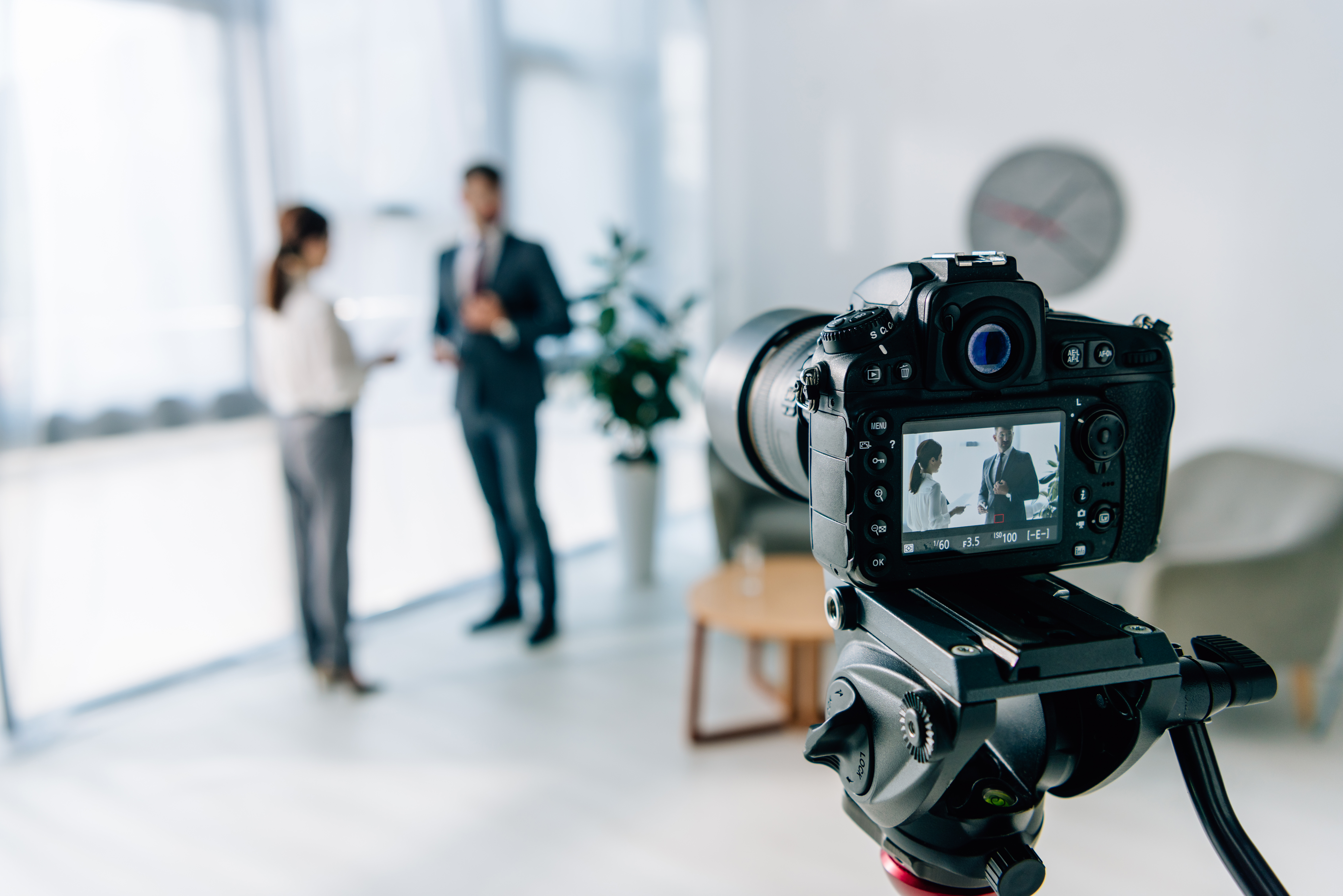 selective focus of digital camera shooting businessman and journalist